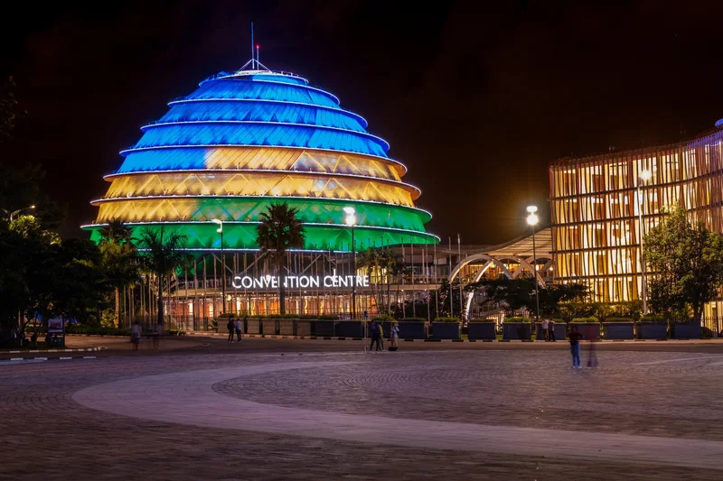 The Kigali Convention Centre dome lit up at night in blue, yellow and green